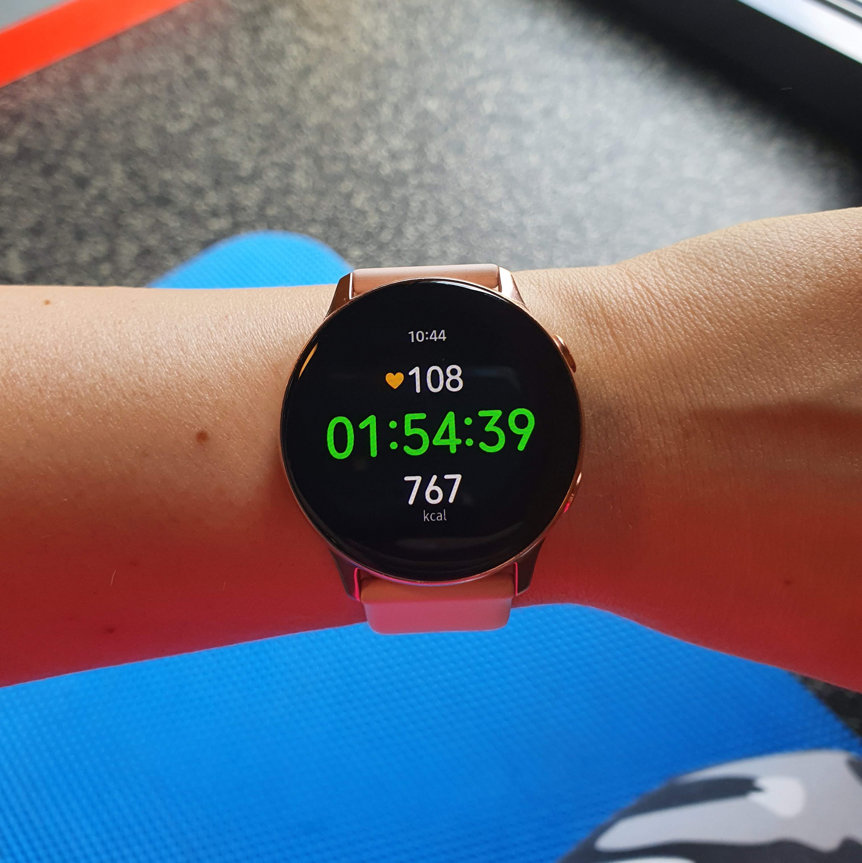 Fotka mých chytrých hodinek na konci mého tréninku v posilovně. Ukazují čas 1:54:39 a 767 spálených kcal.