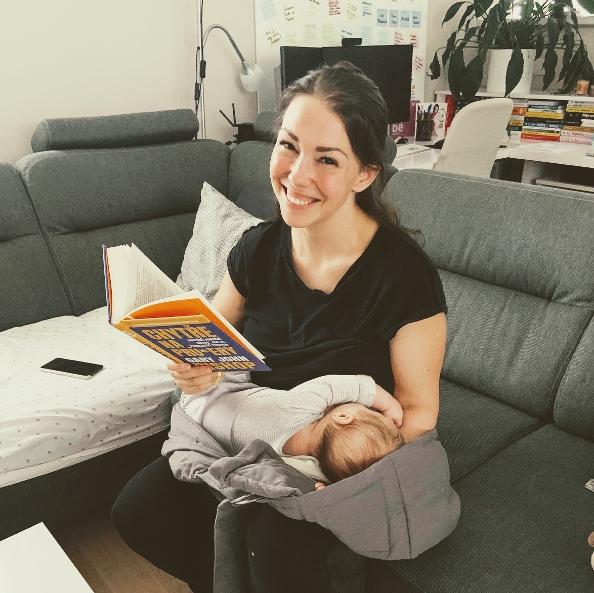 Fotka, jak sedím na gauči, jednou rukou přidržuju spícího tříměsíčního syna, který mi usnul na klíně, a v druhé ruce držím knížku, kterou si takto v pár minutách klidu čtu.